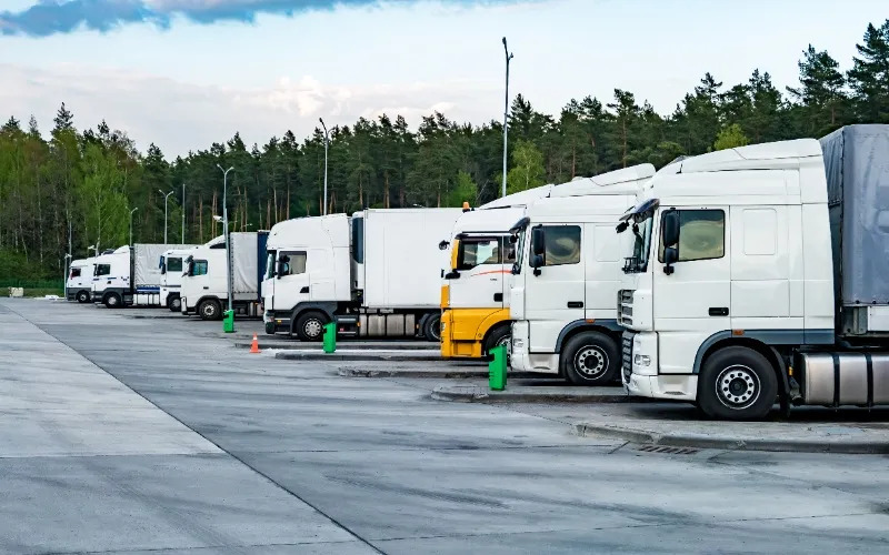 Multiple trucks parked at logistics hub representing full and partial loads Multiple trucks parked at logistics hub representing full and partial loads